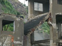 an old run down building with stairs leading up to the second floor and another window