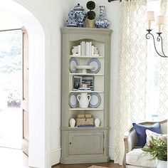 a living room filled with furniture and a book shelf in front of a doorway that leads to a patio