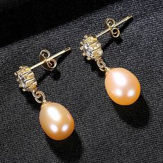 Enhance your natural glow with the right kind of luster, through the splendor of real pearl earrings. Less is definitely more when it comes to these dainty, yet utterly radiant white pearl drop earrings that capture the light from every angle. Measuring 8mm, the Freshwater pearl earrings are the ideal jewelry piece to compliment your wardrobe. our earrings come in fine settings: 14K yellow gold. Wedding Earrings Dainty Jewelry| Freshwater Pearl Earrings Show your loved one how much they mean to Pearl Drop Earrings Wedding, Gold Wedding Earrings, Double Pearl Earrings, Pearl Earrings Designs, Real Pearl Earrings, Freshwater Pearl Earrings, Jewelry Mirror, Purple Pearl, Gold Pearl Earrings