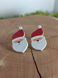 pair of santa claus earrings sitting on top of a piece of wood