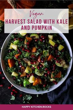 a white bowl filled with kale salad and topped with pomegranates