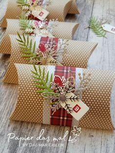 some brown and white paper bags with christmas decorations on them sitting on a wooden table