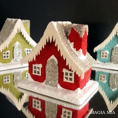 three small houses are decorated with glitters and snowflakes on top of each other