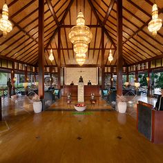 the inside of a restaurant with wooden tables and chandeliers