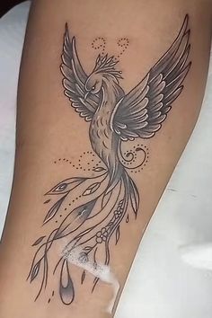 a woman's leg with a bird tattoo on the side of her body and water droplets coming out of it