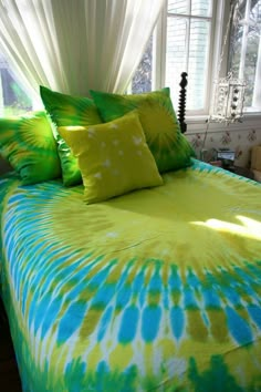 a bed with green and blue comforters and pillows