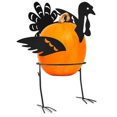 a pumpkin shaped like a turkey sitting on top of a metal stand with black legs