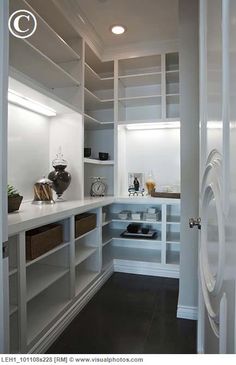 an empty pantry with white shelves and drawers