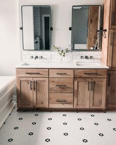 a bathroom with two sinks, mirrors and tiled flooring in the middle of it