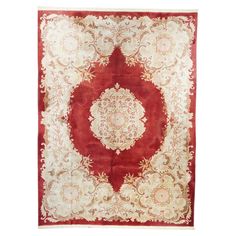 a red and white rug with an ornate design on the center, surrounded by flowers