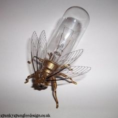 a golden insect sitting on top of a light bulb