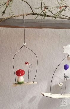 three handmade mobiles with mushrooms and stars hanging from them