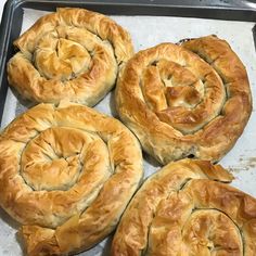 four freshly baked pastries sitting on top of a baking pan, ready to be baked