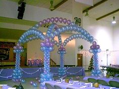 the tables are set up with purple and blue balloons