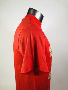 a mannequin wearing a red shirt with gold buttons on it's chest