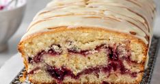 a close up of a loaf of cake on a cooling rack next to a bowl