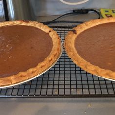 two pies sitting on top of a cooling rack