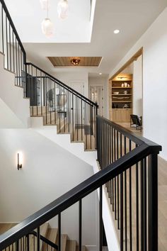 an open staircase with black railings and wood flooring in a modern style home