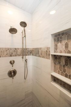 a walk in shower sitting next to a tiled wall