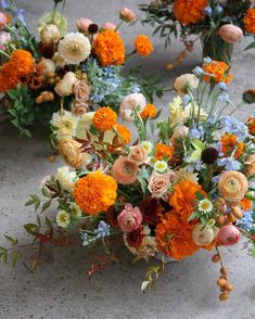 an arrangement of flowers sitting on the ground