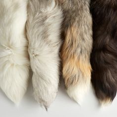 four different colored furs are lined up on a white surface