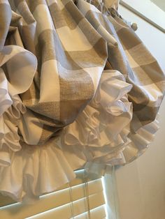 a window curtain with ruffles hanging from it