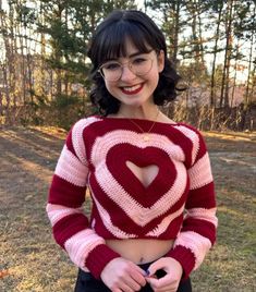 a woman with glasses wearing a red and white knitted heart sweater