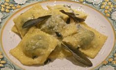 ravioli with sage leaves and cheese on a plate