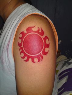 a person with a red tattoo on their arm and the sun in the middle of it