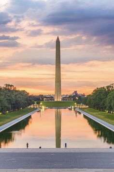 the washington monument in washington dc at sunset with reflecting water and trees on both sides