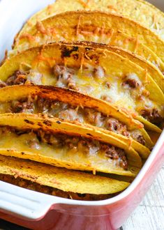 a casserole dish with tortilla shells in it and cheese on top