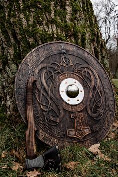 an old wooden shield sitting next to a tree