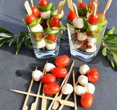 several skewers with tomatoes, mozzarella and basil on them are sitting on a table