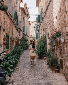 a woman is walking down an alley way