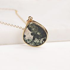 "Moss agate drop pendant necklace on 14k gold filled dainty chain / Moss jewelry / Unique jewelry gifts for her / Gold jewelry and pendants Stone: Moss Agate Stone: 20mm x 18mm Gold chain: 14k gold filled Chain length: 18 inches Clasp: spring ring Arrives in gift box Made in the USA About \"Gold Filled Jewelry\": Also called rolled-gold. These jewelry items are not actually filled with gold. They are made of a base metal covered by sheets of gold in a mechanical bonding process. Effectively a th Gold Minimalist Charm Necklaces With Natural Stones, 14k Gold Pendant Drop Necklace As Gift, Gift 14k Gold Pendant Drop Necklace, Dainty Teardrop Pendant Necklace For Healing, Everyday 14k Gold-filled Necklaces With Natural Stones, Gift Teardrop Pendant Drop Necklace With Natural Stones, Gift Clavicle Chain Charm Necklace With Drop Shape, Charm Necklaces With Clavicle Chain For Gifts, Delicate 14k Gold Filled Drop Necklace For Gift