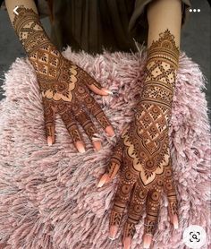 two hands with henna tattoos on them