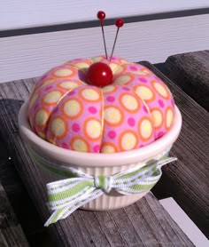 a cake sitting on top of a wooden table next to a fence with a cherry in it