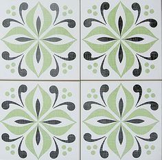 four green and black tile designs on the wall