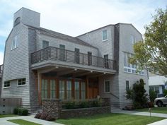 a two story house with large windows and balconies on the second floor is shown