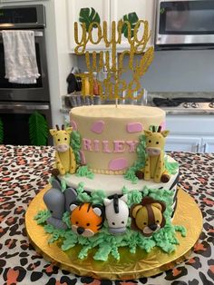 a birthday cake decorated with animals on a table