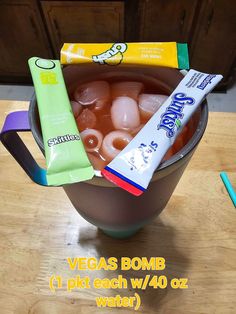 a cup filled with ice and candy on top of a wooden table