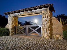 a stone building with a wooden gate at night