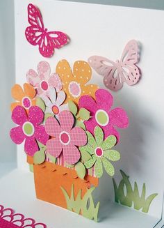 a greeting card with flowers and butterflies on the front, sitting on top of a table