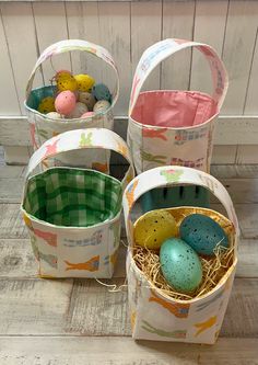 three buckets filled with eggs sitting on top of a wooden floor next to each other