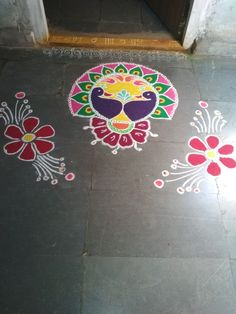 two colorfully painted flowers on the ground next to a door