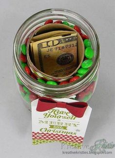 a jar filled with candy and money sitting on top of a table