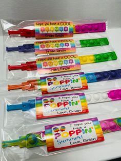 four different colored crayons in plastic bags with name tags on the top and bottom