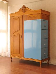 a blue cabinet sitting on top of a hard wood floor next to a white wall