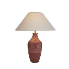 a table lamp with a white shade on the base and a brown vase underneath it