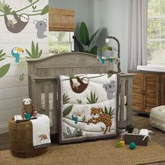 a baby crib in a nursery with animals on it and jungle themed wallpaper